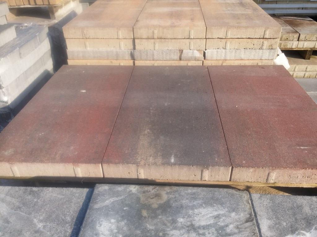 Roodbruine grote terrastegels gestapeld op pallets