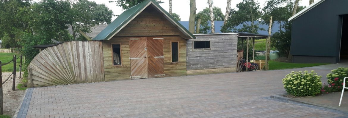 Opnieuw gelegde klinkerbestrating voor een houten schuur aan de Vierhuizenweg in Oldebroek