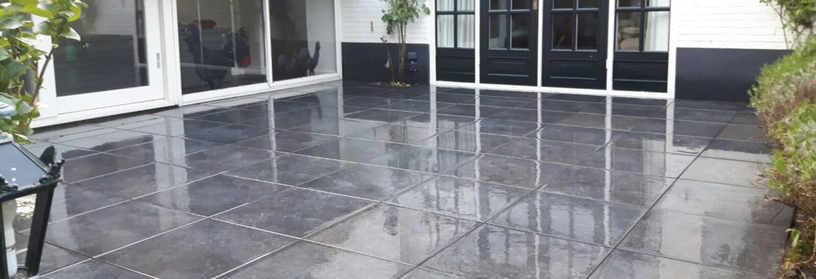 Donker keramisch terras van grote tegels voor de tuindeuren van een woning aan de Molenweg in Elburg