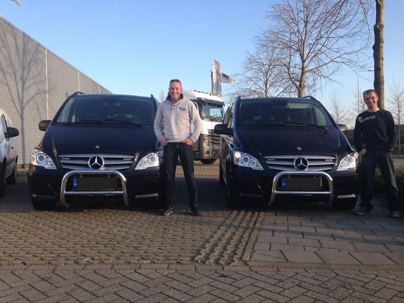 Het team van Fleming Infra Voorziening bij de twee zwarte Mercedes-bussen voor de loods in Elburg
