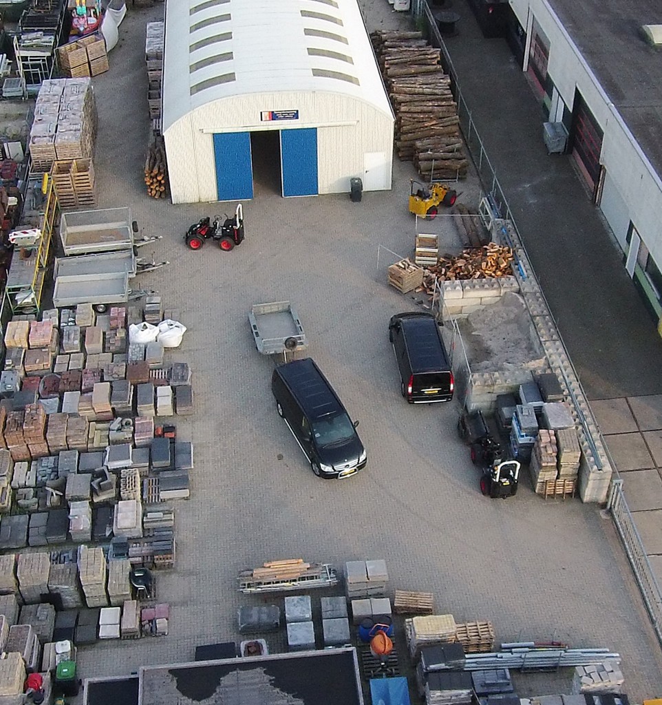 Luchtfoto van de loods en de opslag van bestratingsmaterialen aan de Uiterwaardenstraat in Elburg